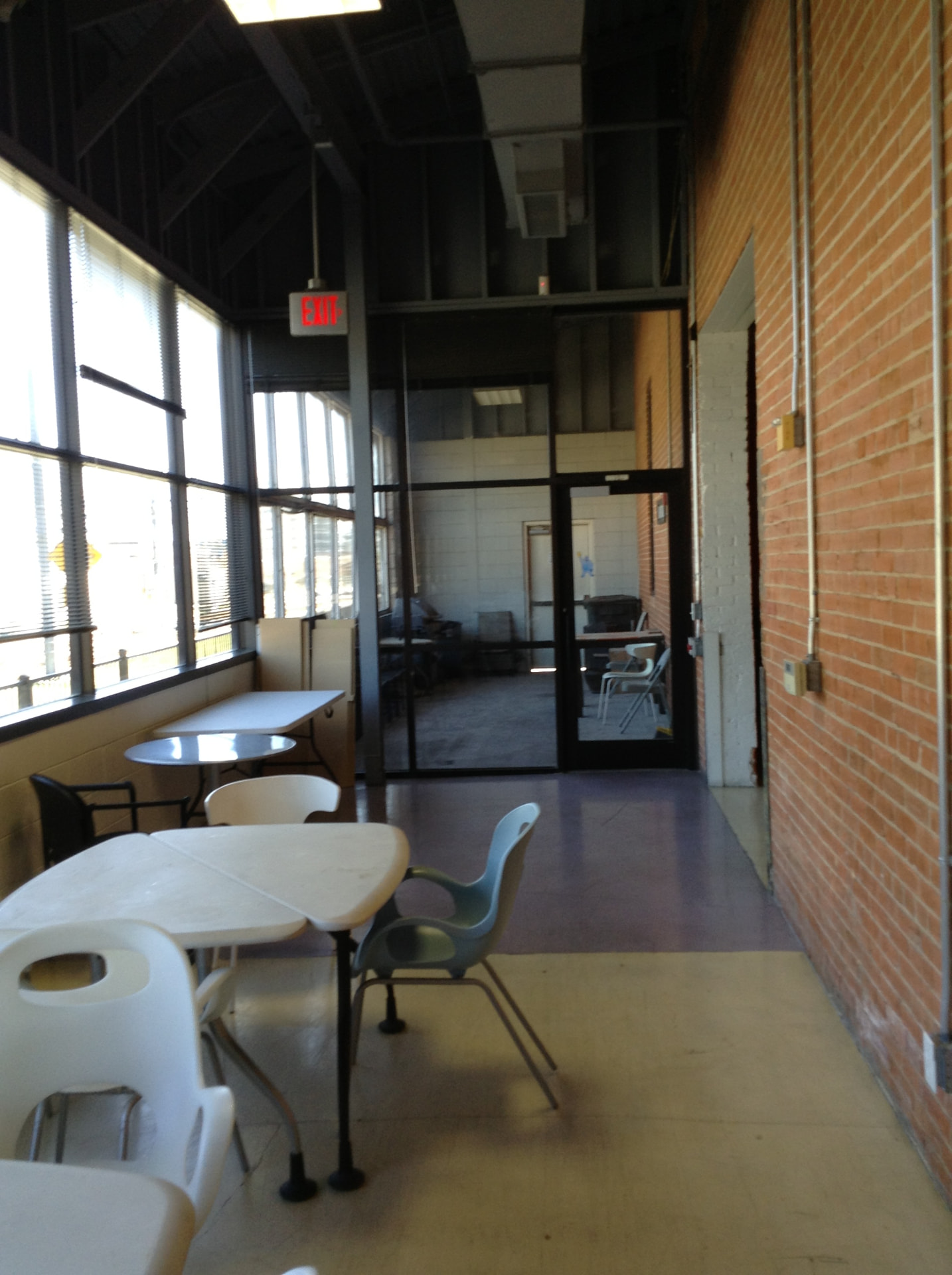 Creative office café with exposed brick structure and translucent panel mezzanine walls
