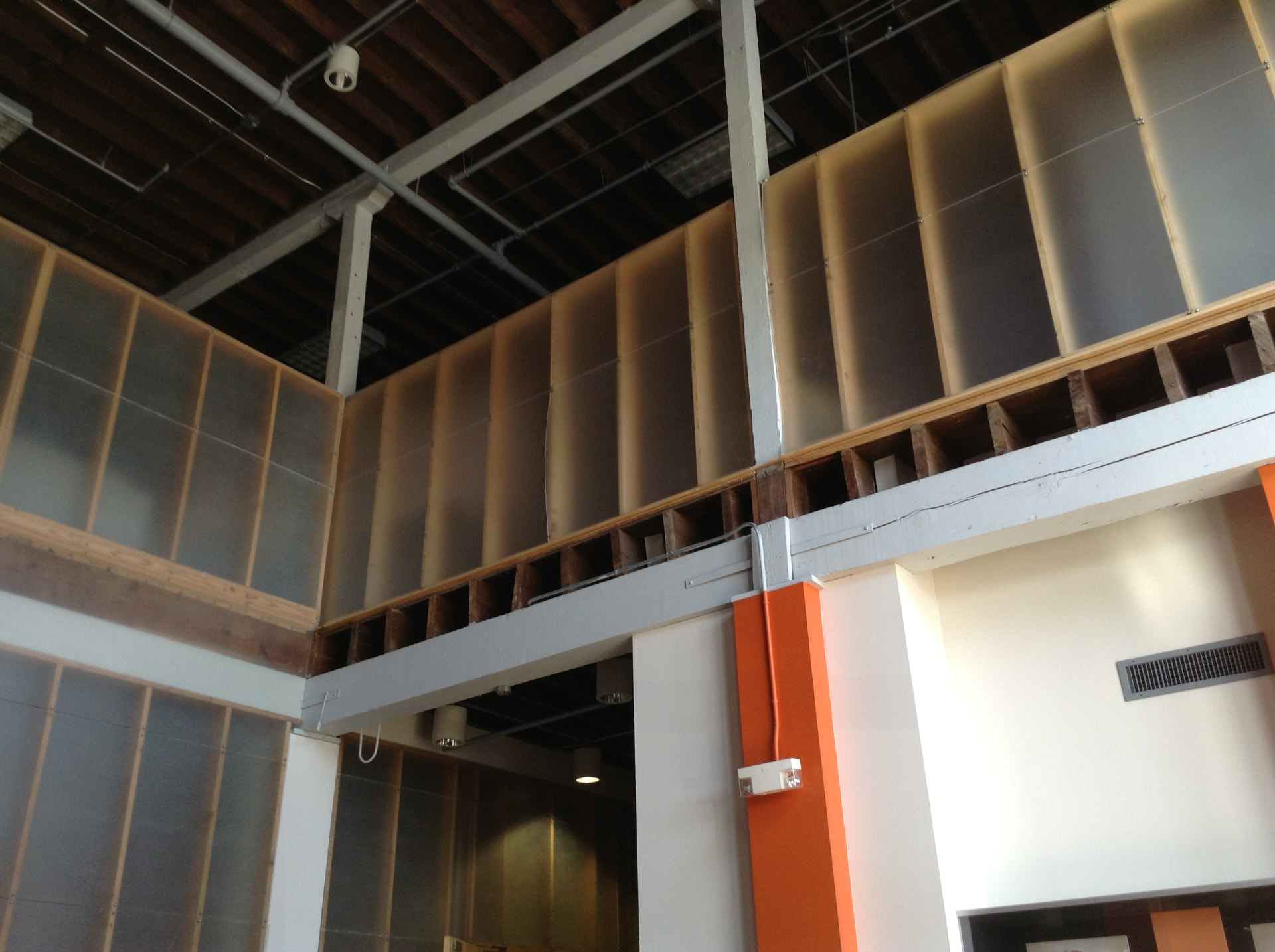 Translucent panel mezzanine glazing installed against exposed structure