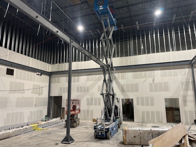 High-bay metal stud framing with drywall and taping in progress